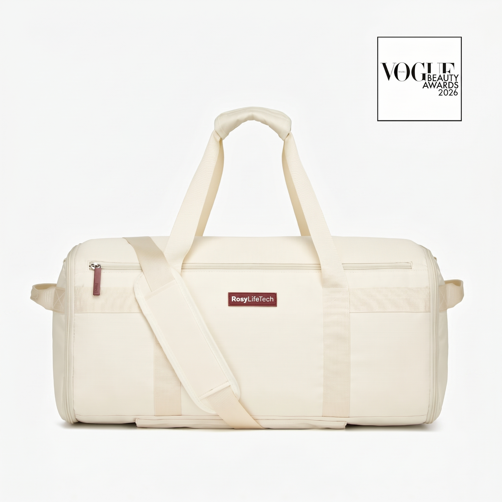 Beige duffel bag with a visible brand label on a white background, featuring the Vogue Beauty Awards logo.